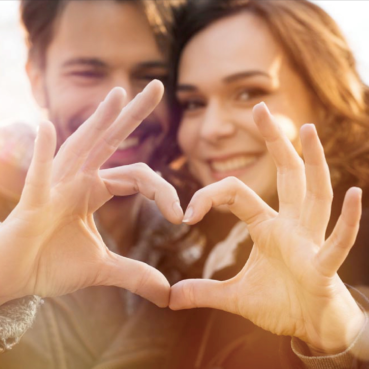 couple making a heart with their hands